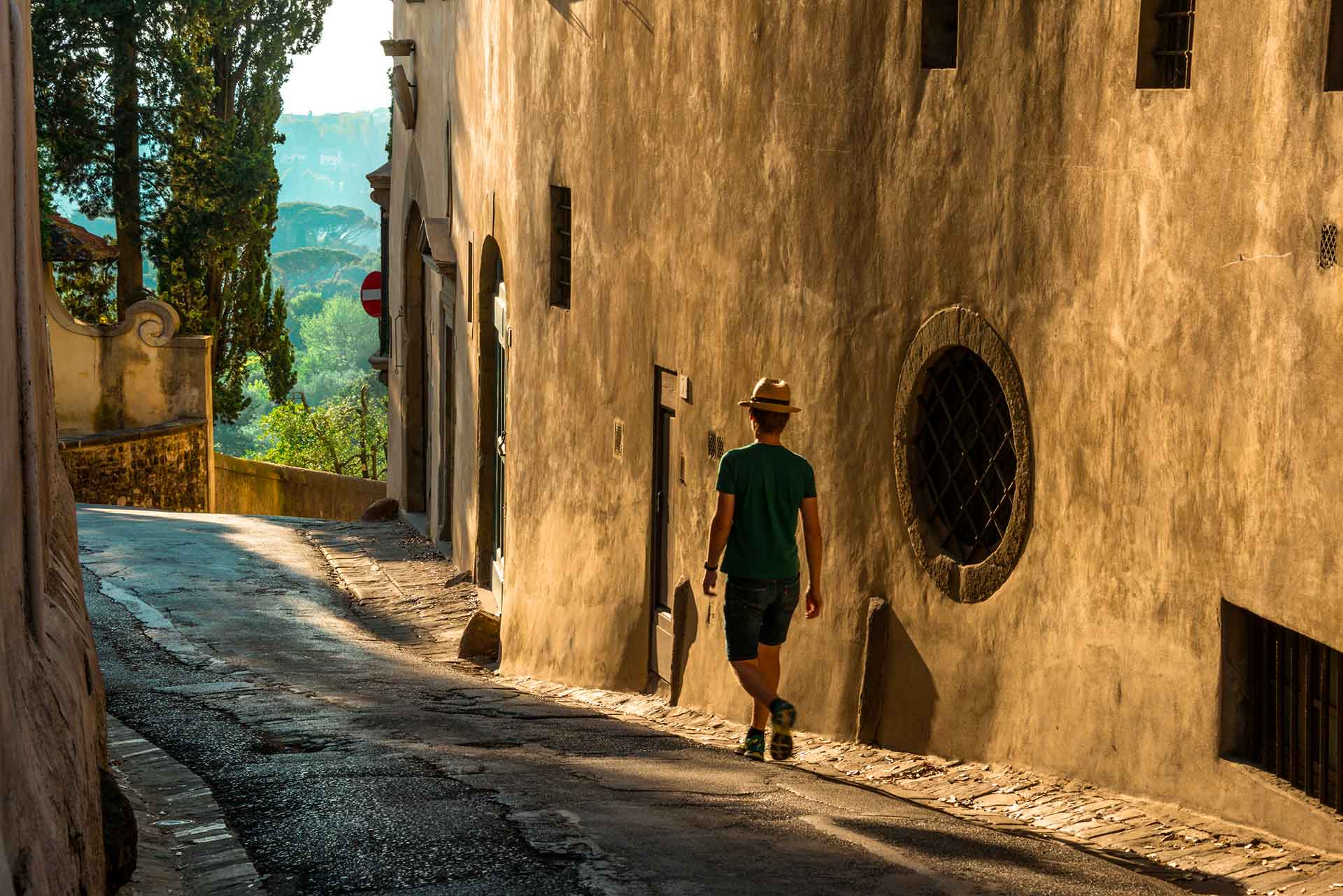 giovane-maschio-solo-che-cammina-lungo-la-strada-accanto-un-vecchio-edificio-cemento