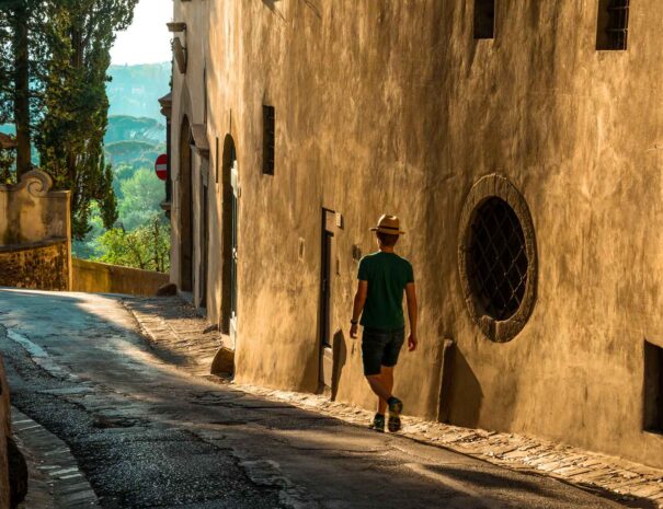 giovane-maschio-solo-che-cammina-lungo-la-strada-accanto-un-vecchio-edificio-cemento